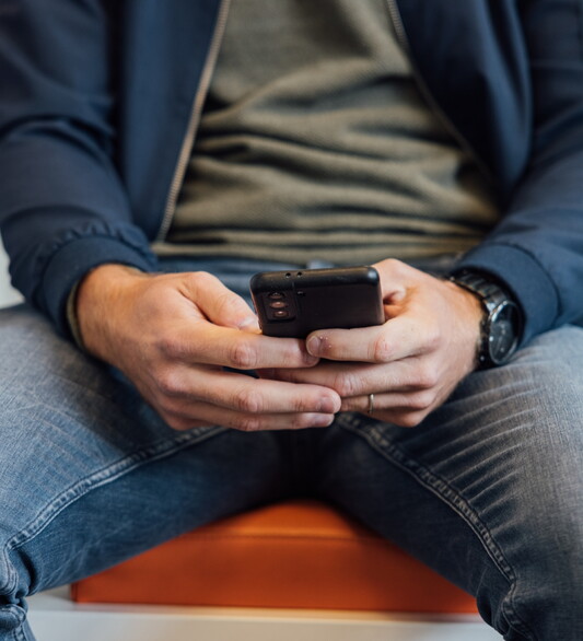 Man op telefoon in wachtkamer Jong JGZ